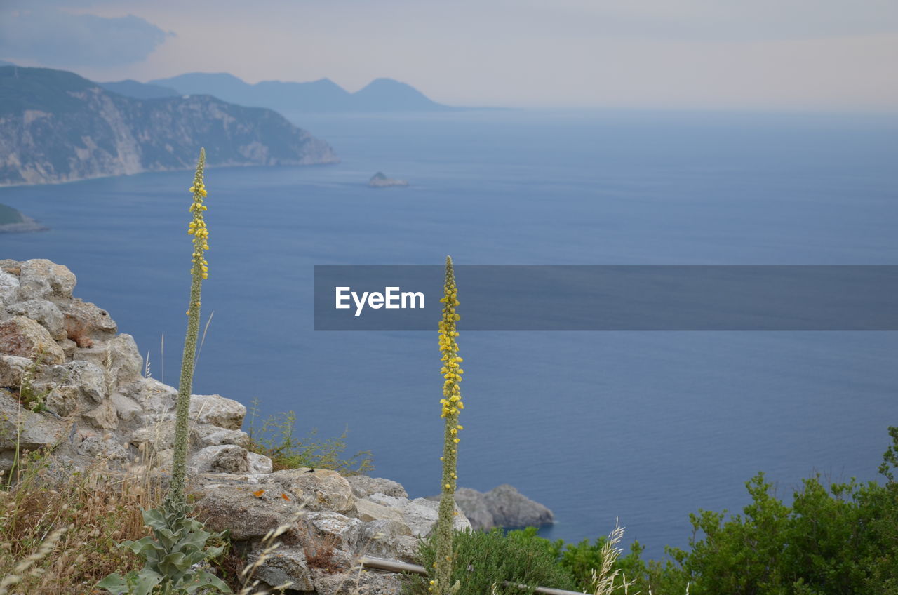 SCENIC VIEW OF SEA BY MOUNTAINS AGAINST SKY