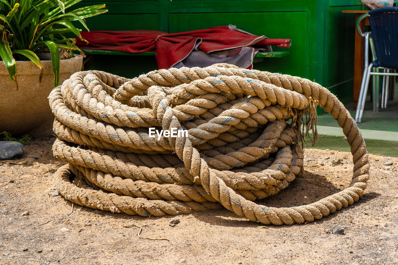 CLOSE-UP OF ROPE TIED UP ON WOODEN POST