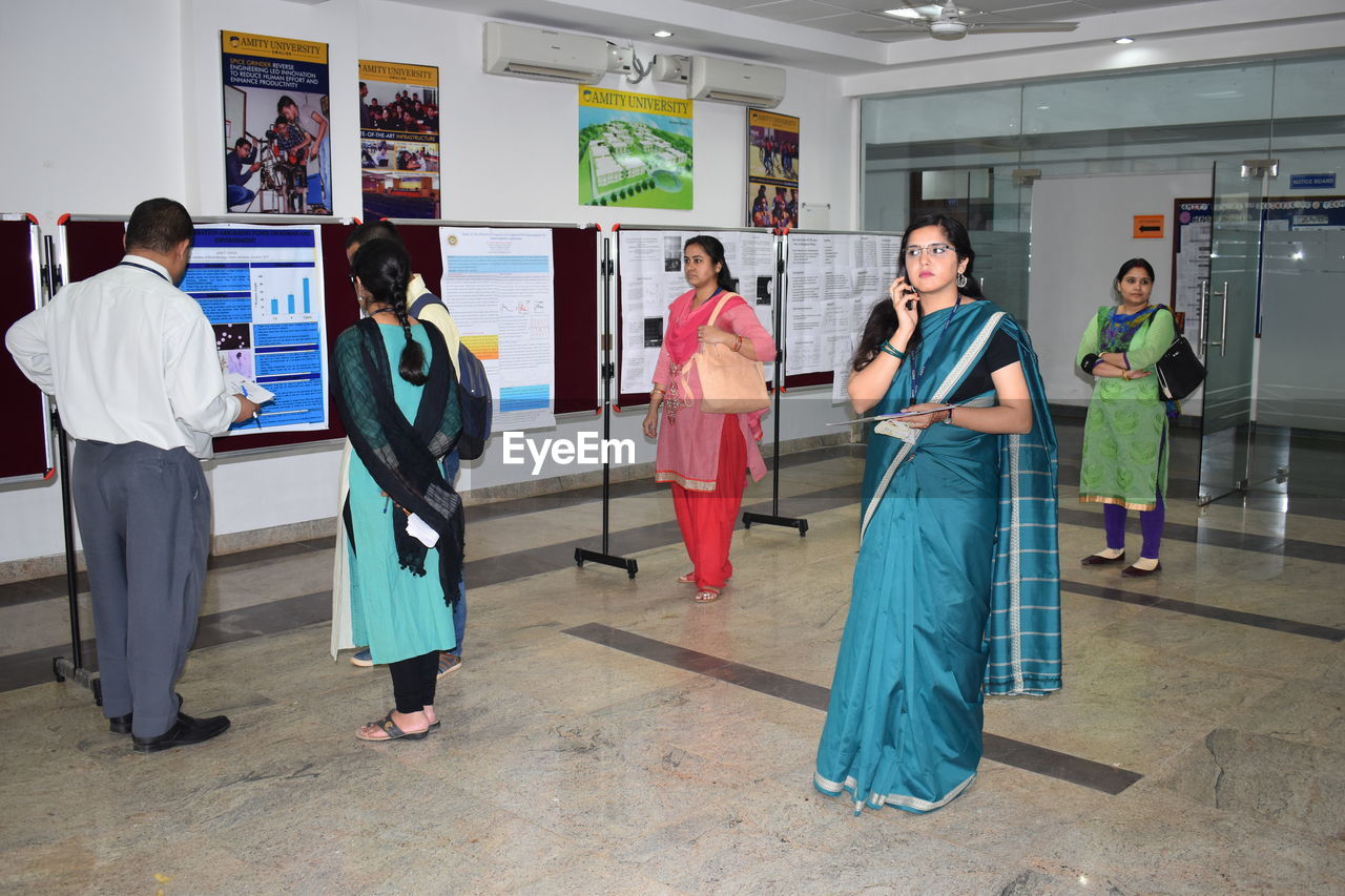 Woman wearing sari while standing in college corridor