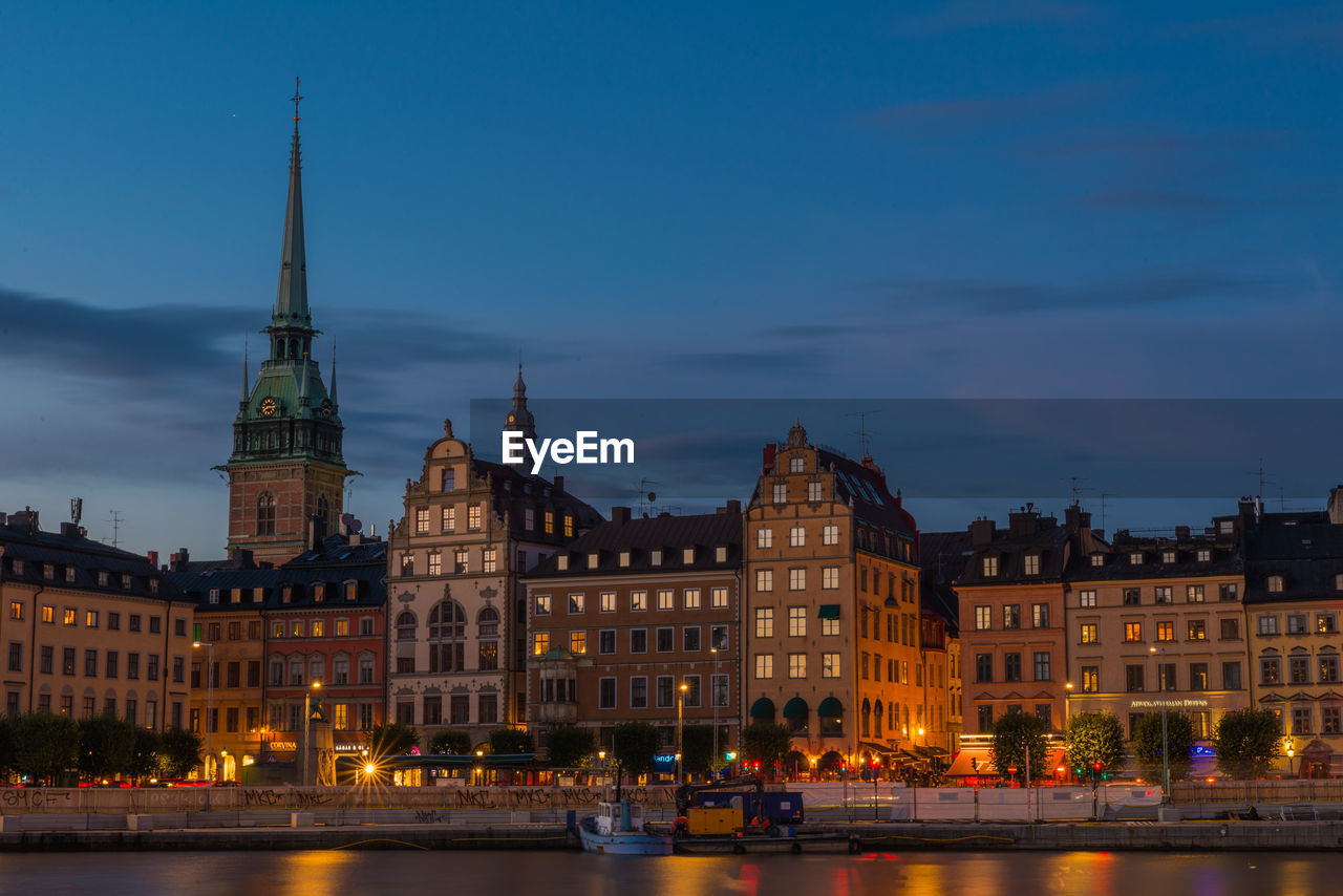 ILLUMINATED BUILDINGS IN CITY AGAINST SKY