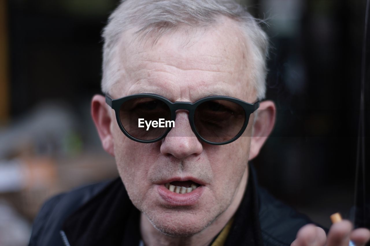 glasses, portrait, headshot, one person, adult, sunglasses, vision care, fashion, men, eyewear, person, human face, close-up, front view, focus on foreground, facial hair, human hair, eyeglasses, goggles, emotion, gray hair, hairstyle, human head, looking at camera, beard, lifestyles