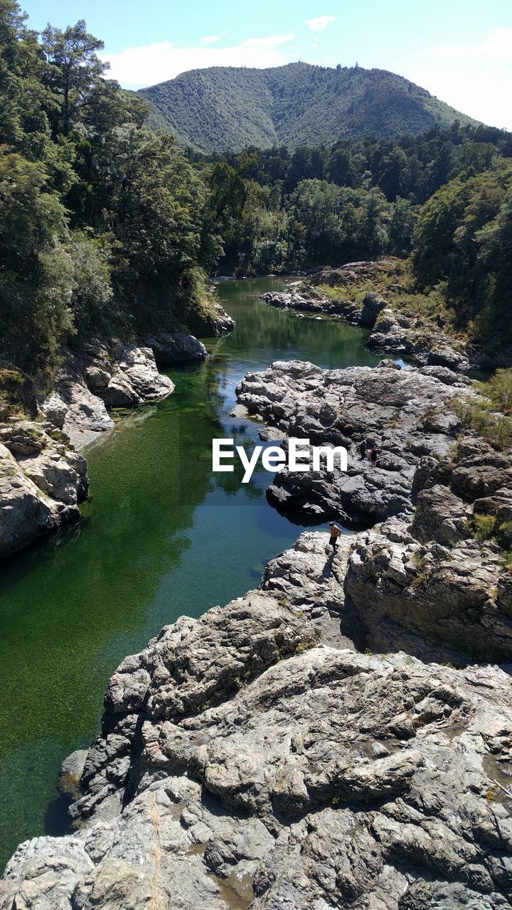 SCENIC VIEW OF RIVER BY MOUNTAIN AGAINST SKY