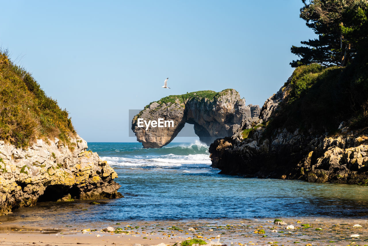 Scenic view of sea against blue sky in rocky coast. castro de las gaviotas, and beach of the huelga