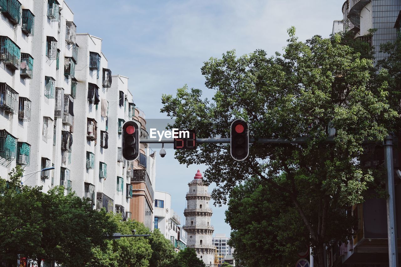 LOW ANGLE VIEW OF STREET AMIDST BUILDINGS AGAINST SKY