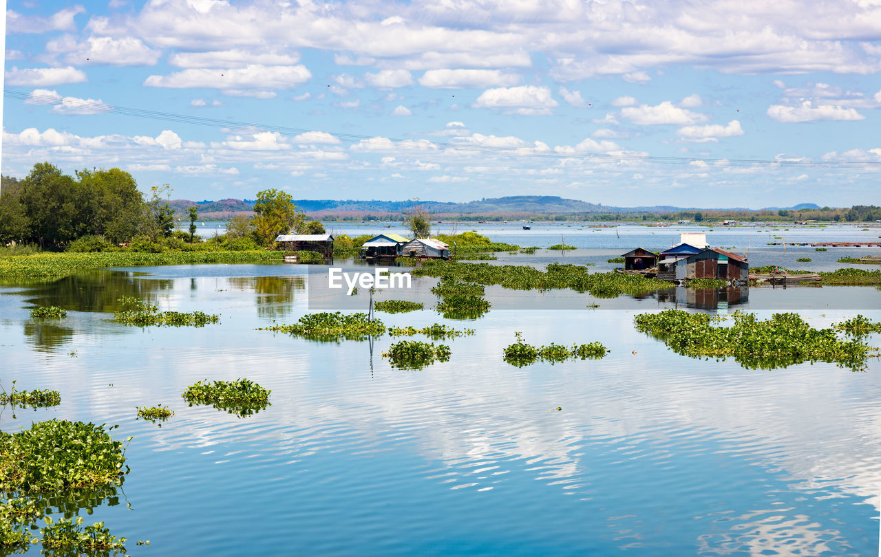 Scenic view of lake by building against sky