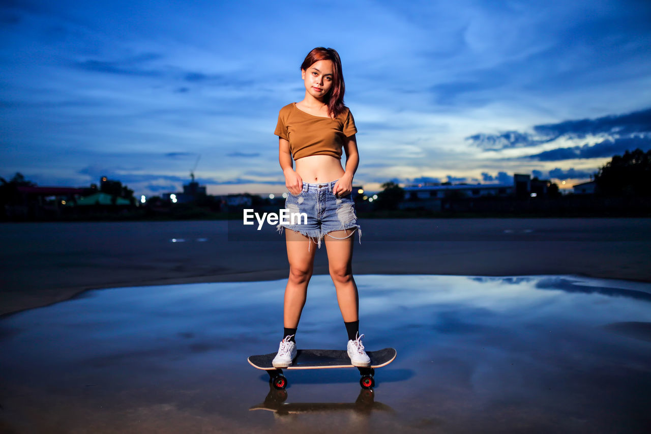 Asian women playing surf skate or skates board outdoors.