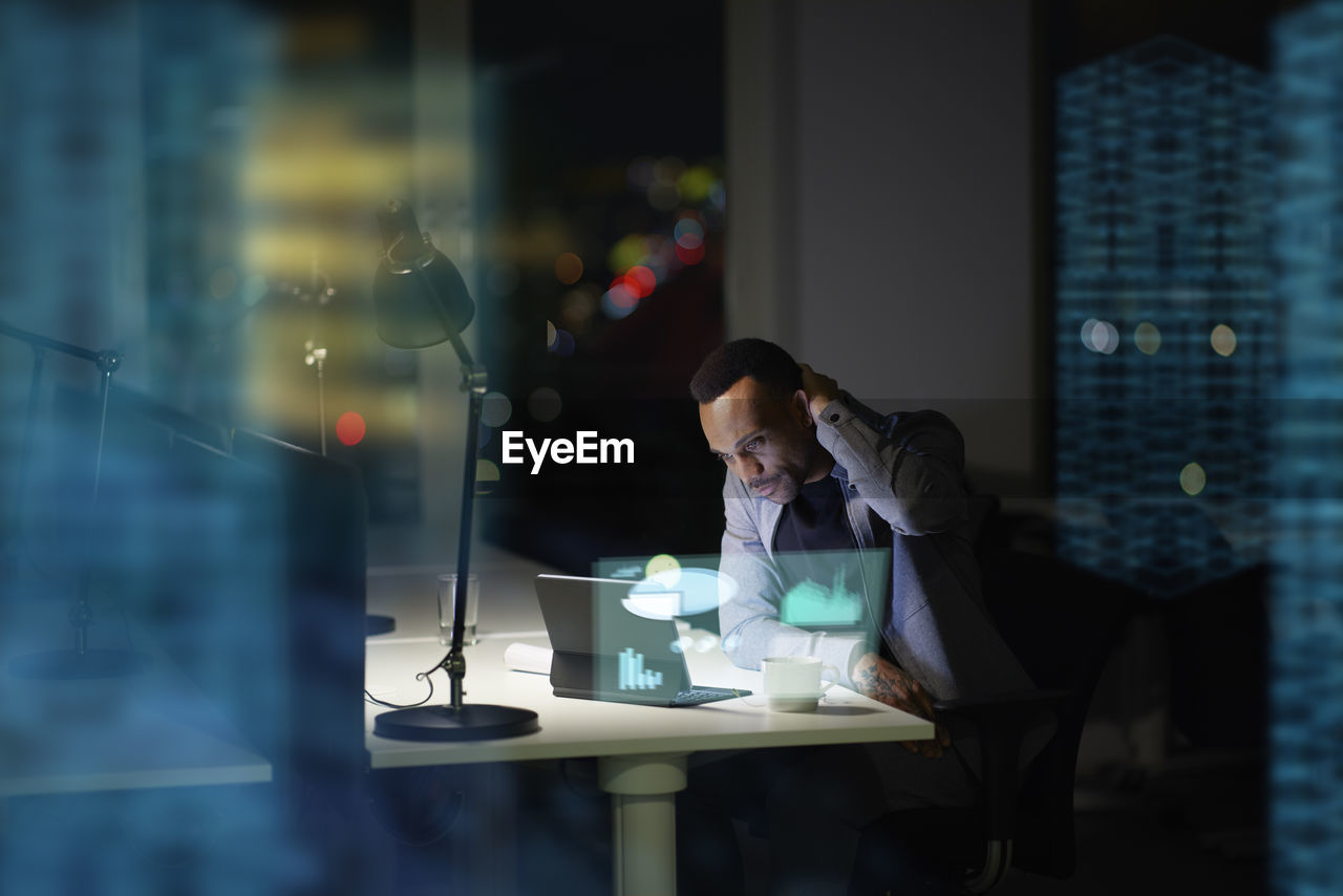 Young businessman working in office at night