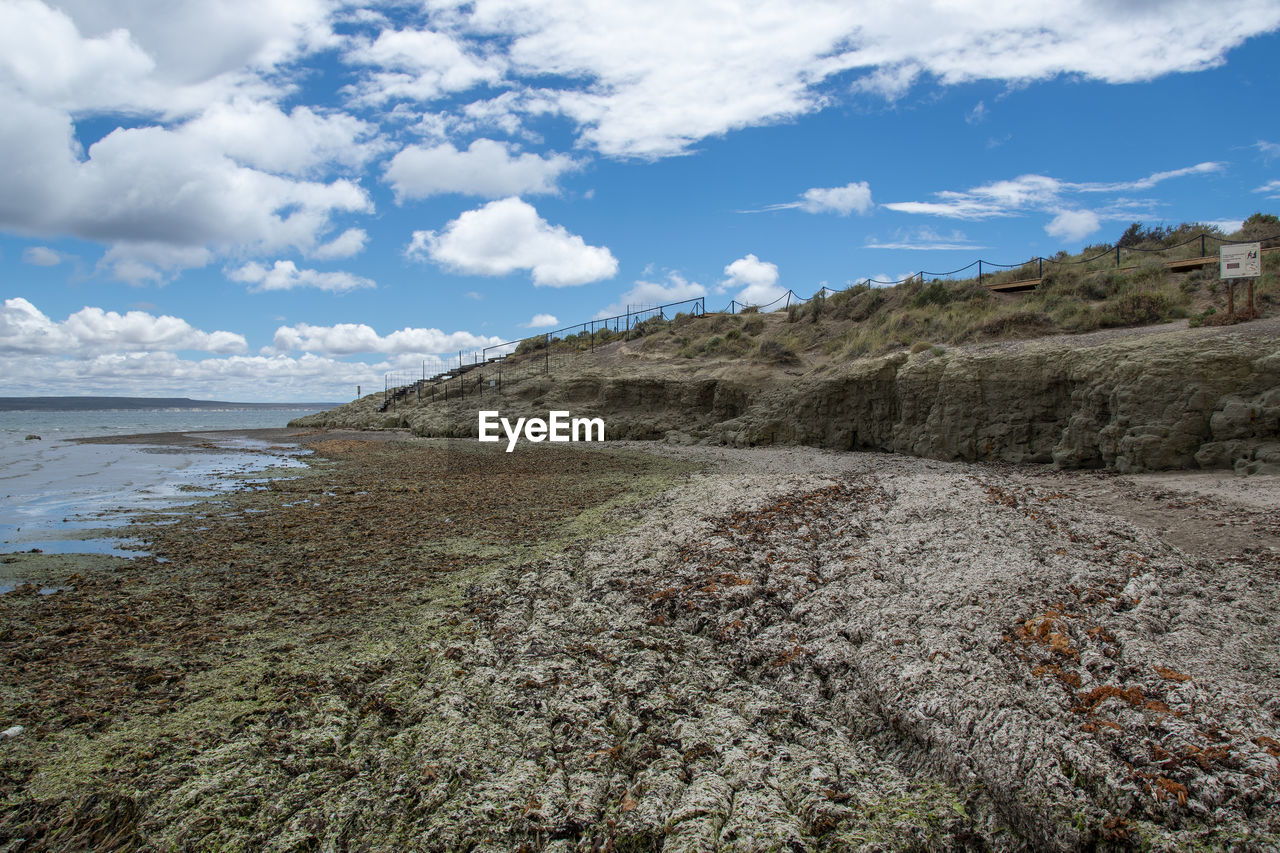 sky, cloud, sea, land, water, environment, scenics - nature, rock, nature, landscape, coast, beauty in nature, shore, beach, cliff, mountain, terrain, travel destinations, geology, no people, travel, tranquility, day, tranquil scene, non-urban scene, outdoors, tourism, wilderness, blue, plant, sand, ocean, coastline