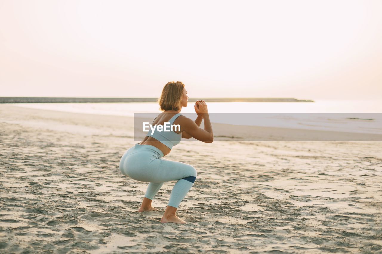 Attractive athletic woman training outdoors with a resistance elastic band. a girl in sports clothes 