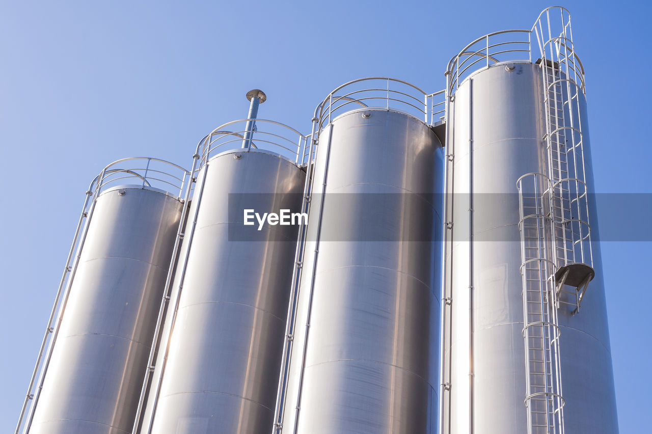 Low angle view of silos against clear sky