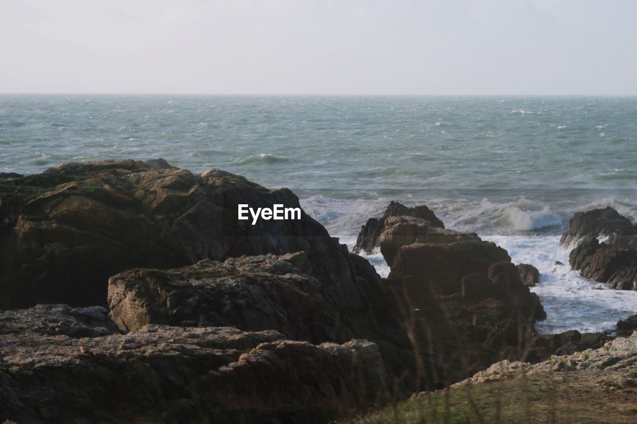 ROCK FORMATION IN SEA AGAINST SKY