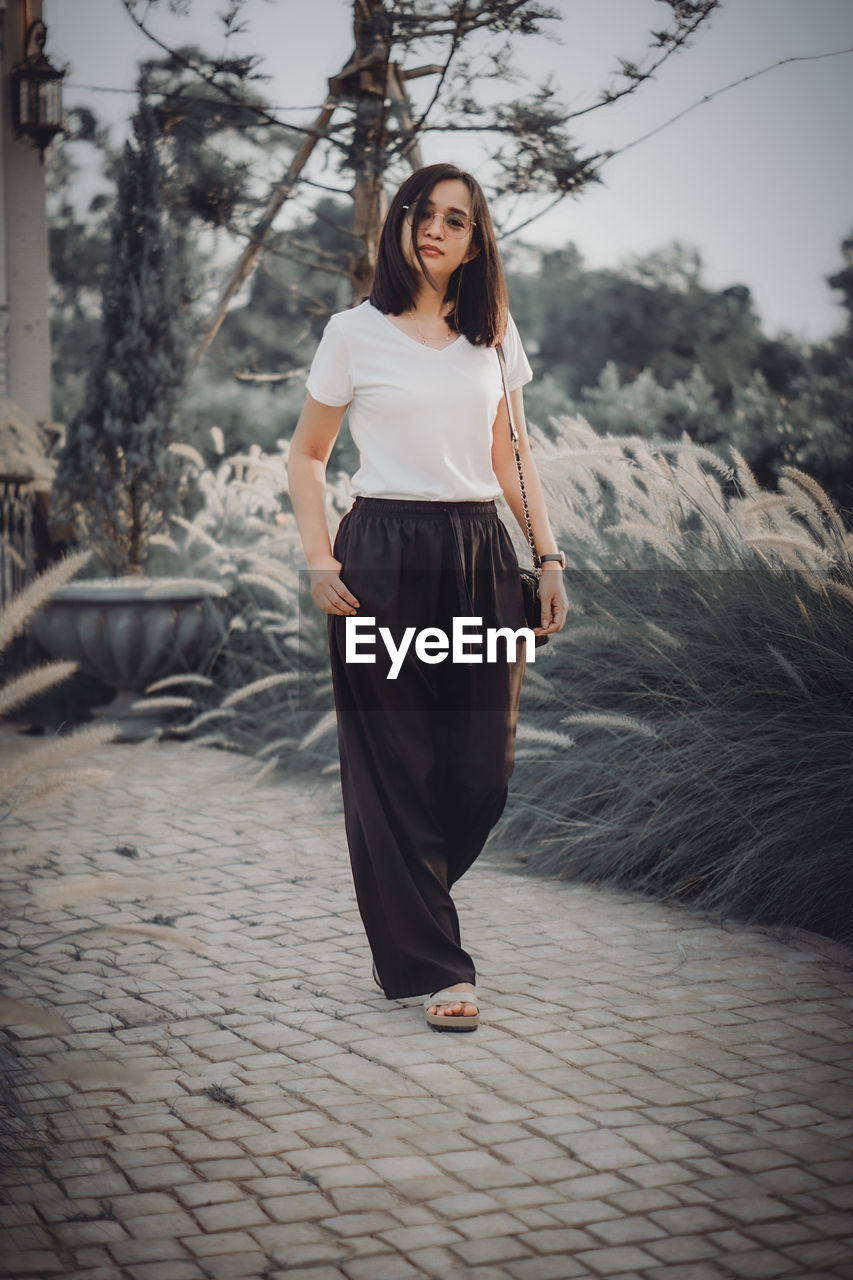 Young woman standing on footpath