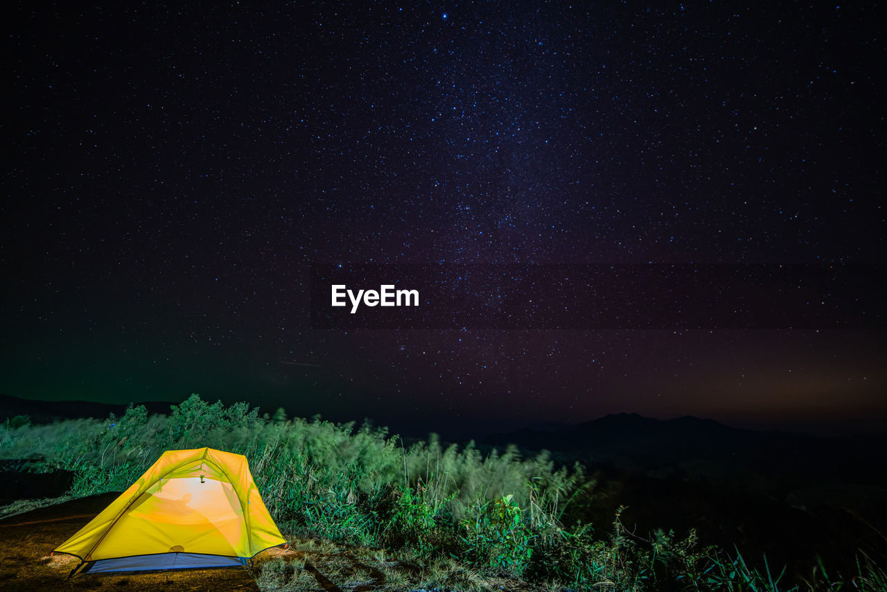 Tent in field against sky at night