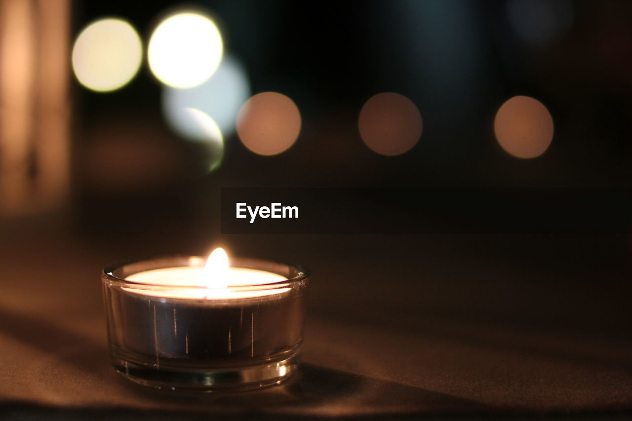 Close-up of illuminated candles on table