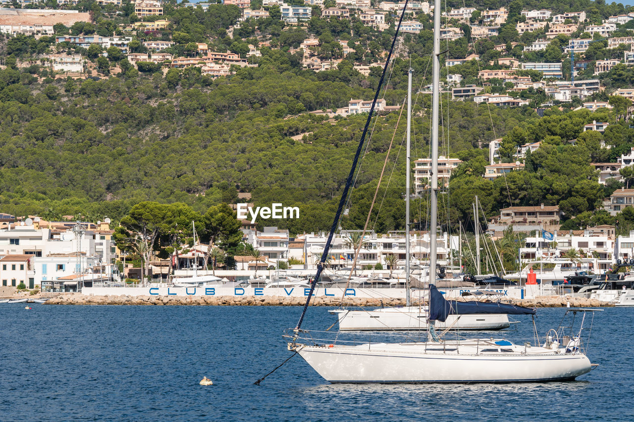 boats in sea against mountain