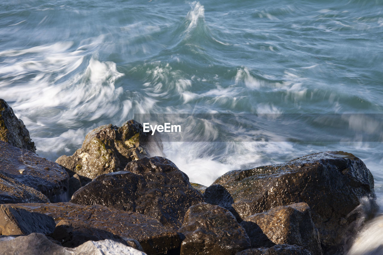 water, sea, rock, ocean, wave, shore, motion, coast, beauty in nature, beach, nature, wind wave, land, no people, scenics - nature, day, outdoors, body of water, sports, water sports, high angle view, terrain, rock formation, splashing