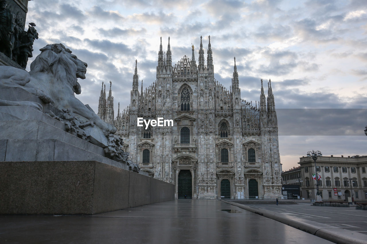 Low angle view of milan cathedral against cloudy sky at dusk