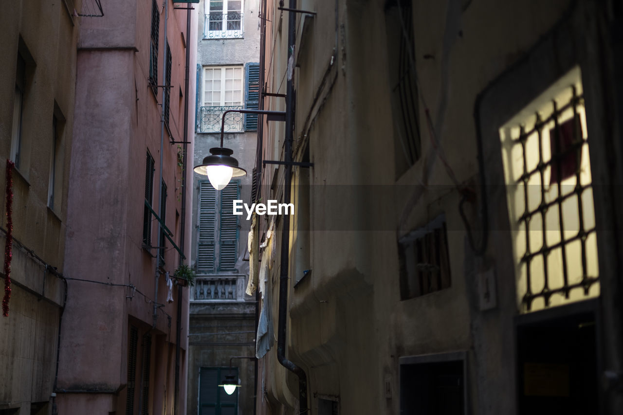 Low angle view of illuminated light bulbs in alley