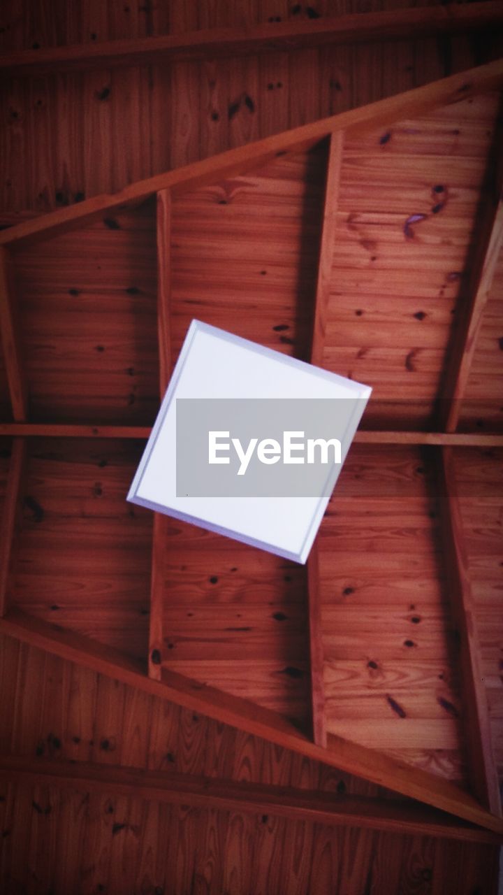 HIGH ANGLE VIEW OF EMPTY CHAIR ON WOODEN FLOOR