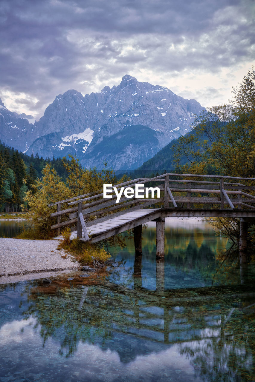 Scenic view of lake by snowcapped mountains against sky