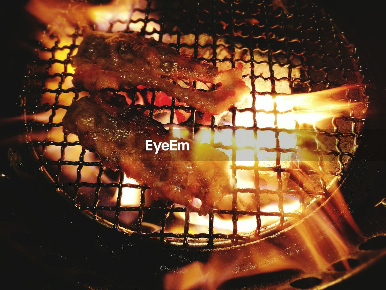 High angle view of meat cooking on barbecue grill at night