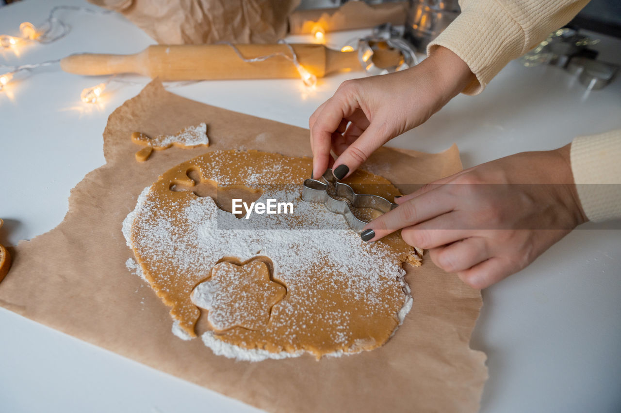 Making christmas gingerbread cookies from dough, holding a mold with your hands