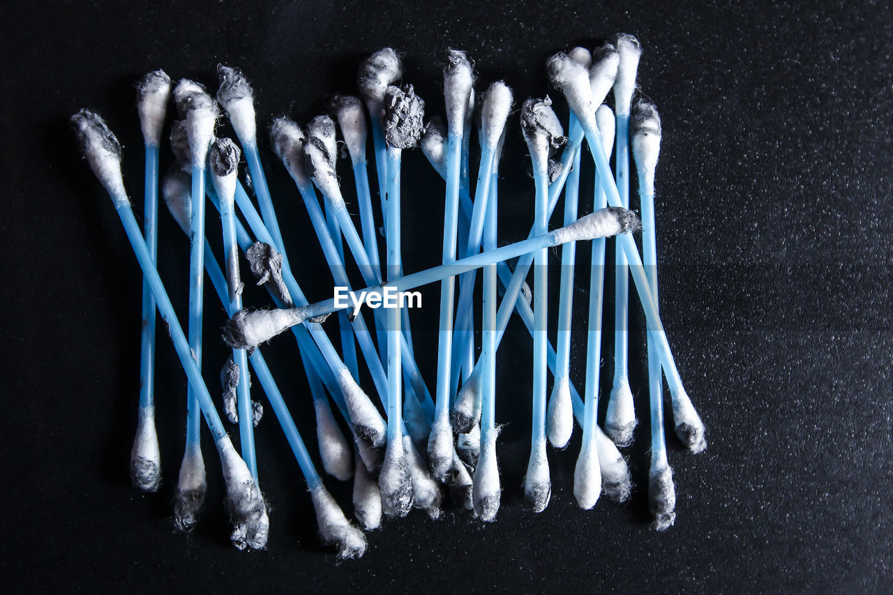 Close up of messy blue cotton swabs on black background