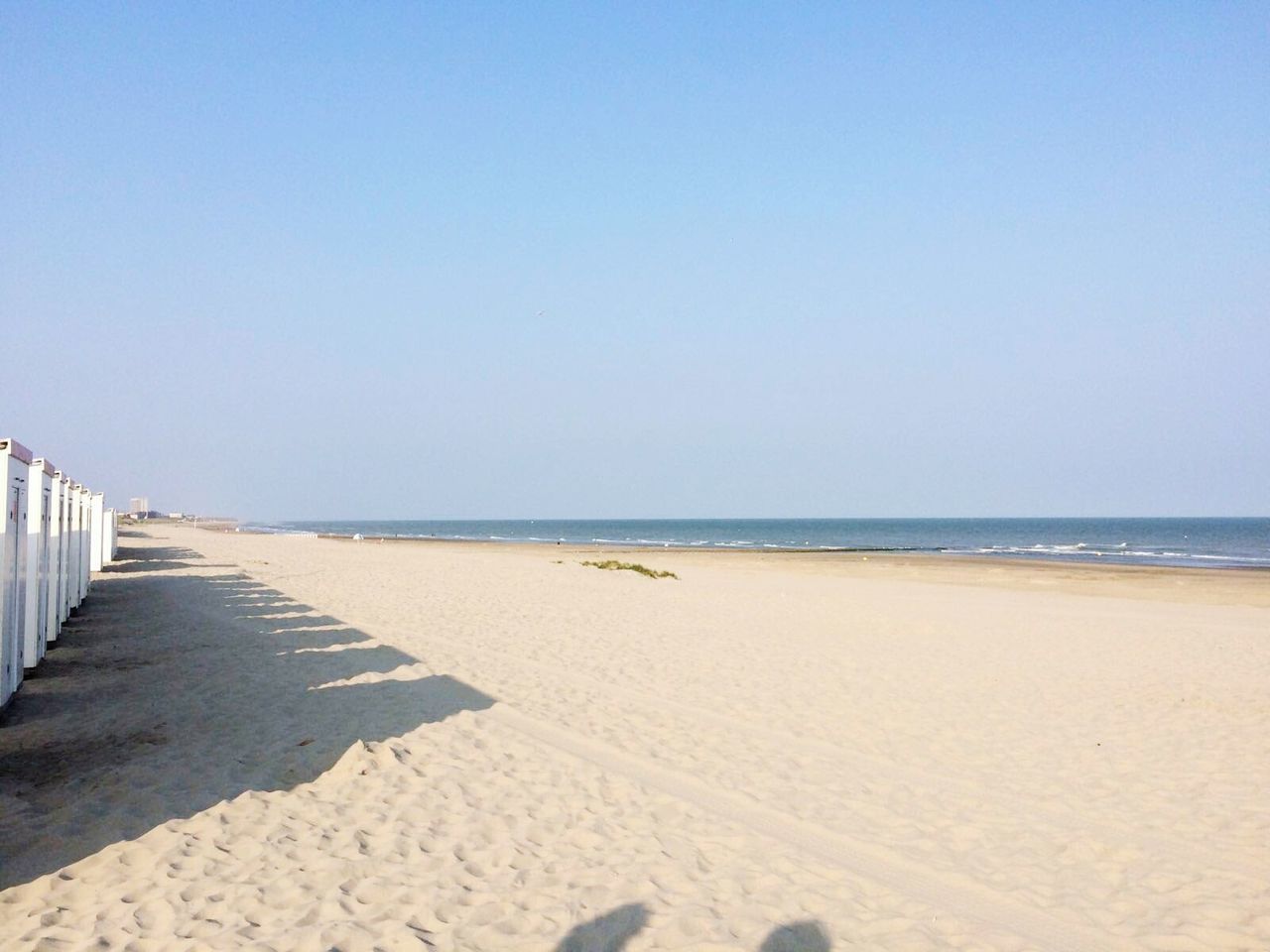 View of calm beach against blue sky