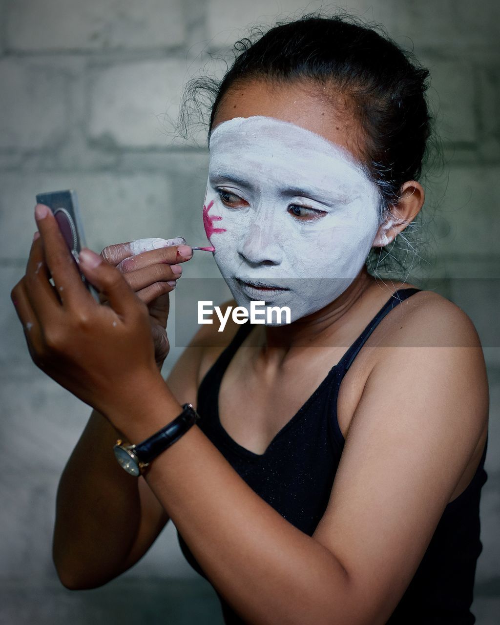 Close-up of woman applying face paint