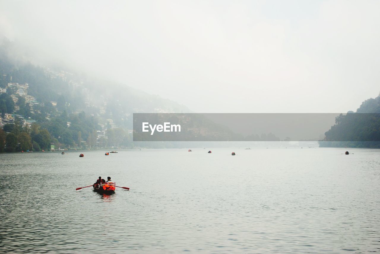 People on boat against sky