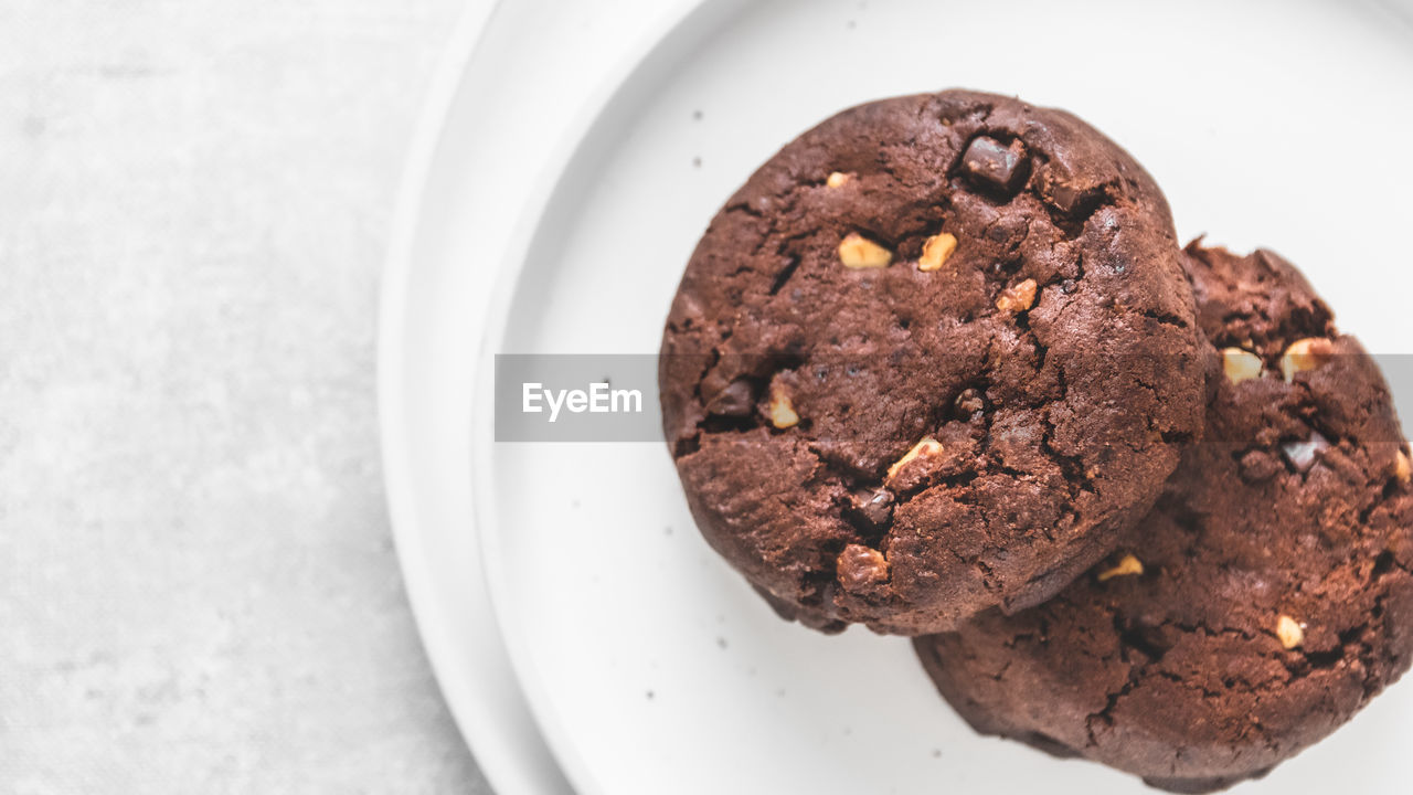 High angle view of chocolate cookies on white plates on table