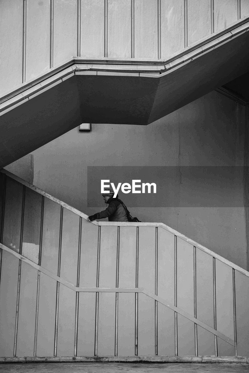 Man standing on staircase of modern building