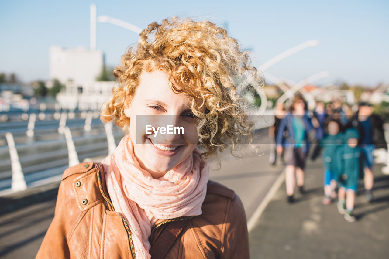 Portrait of smiling woman against sky