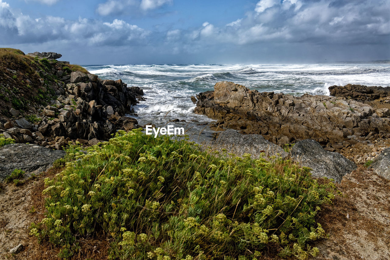 SCENIC VIEW OF ROCKS BY SEA AGAINST SKY