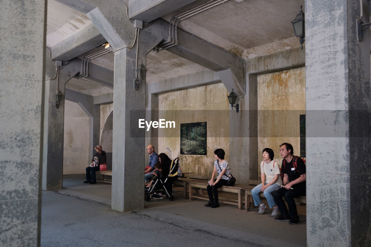 GROUP OF PEOPLE SITTING IN BUILDING