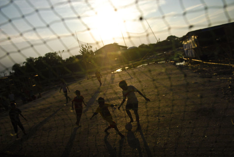 Children playing football during sunset