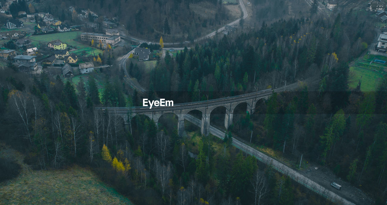 HIGH ANGLE VIEW OF BRIDGE OVER MOUNTAIN AGAINST TREES