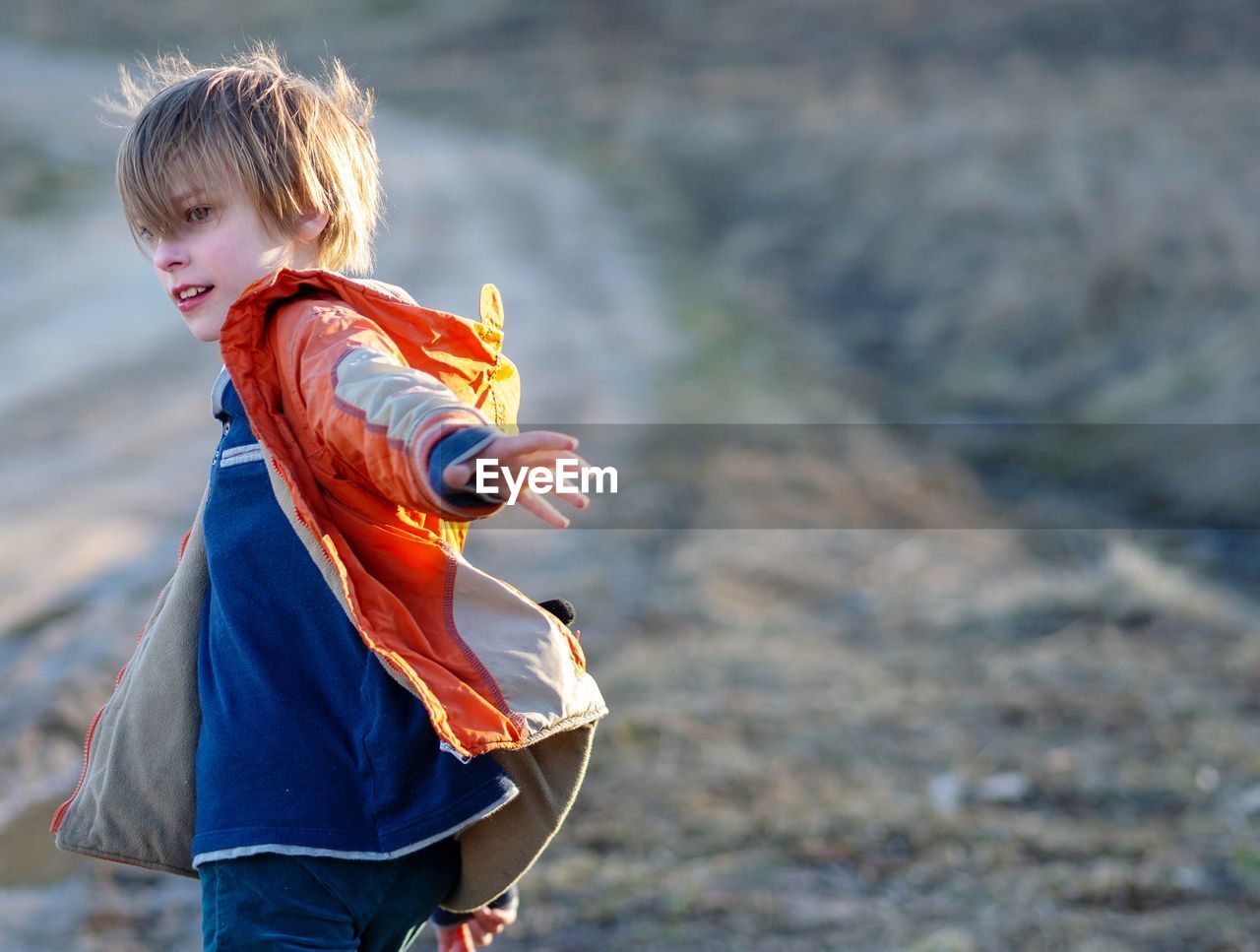 Side view of cute boy playing on land