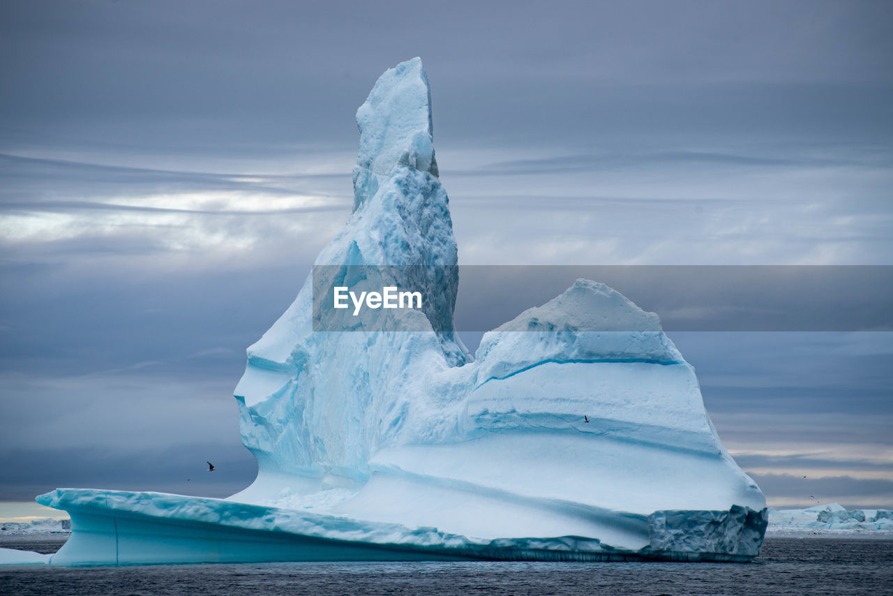 Scenic view of ice berg against sky during winter