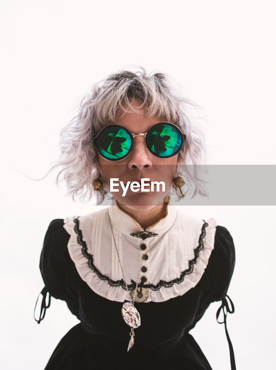 Portrait of woman wearing sunglasses against white background