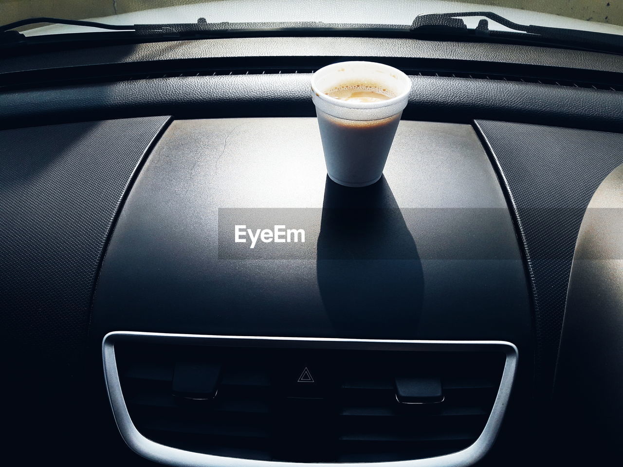 CLOSE-UP OF COFFEE CUP WITH CAR