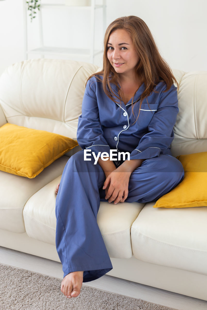 portrait of young woman sitting on sofa