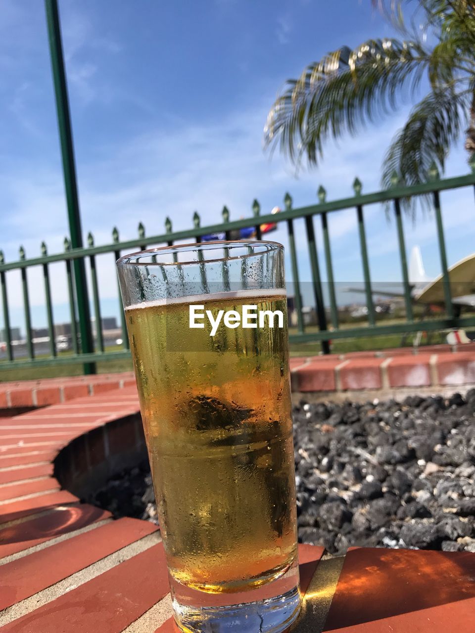 Close-up of drink on table at beach against sky