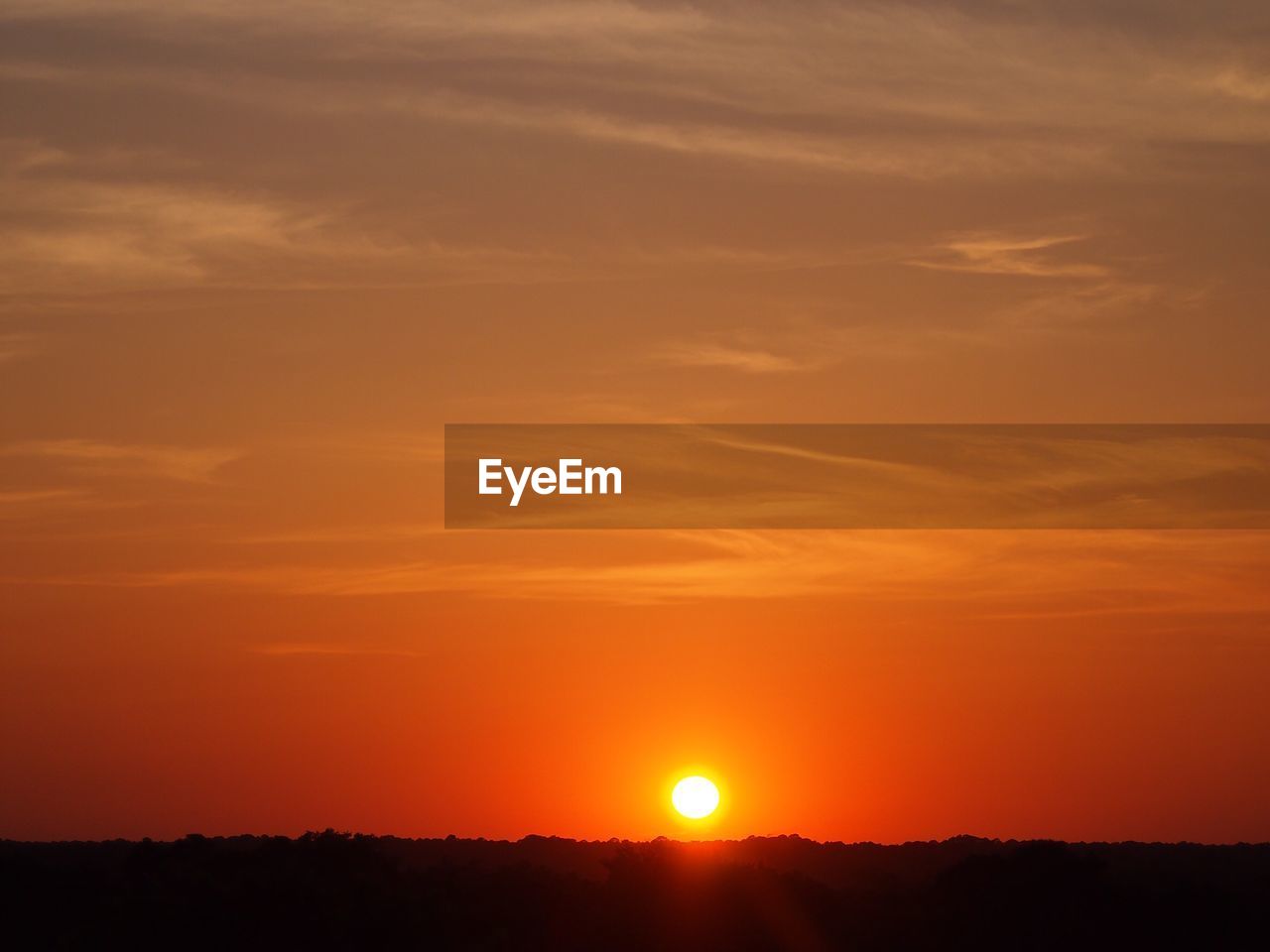 SCENIC VIEW OF SILHOUETTE FIELD AGAINST SKY AT SUNSET