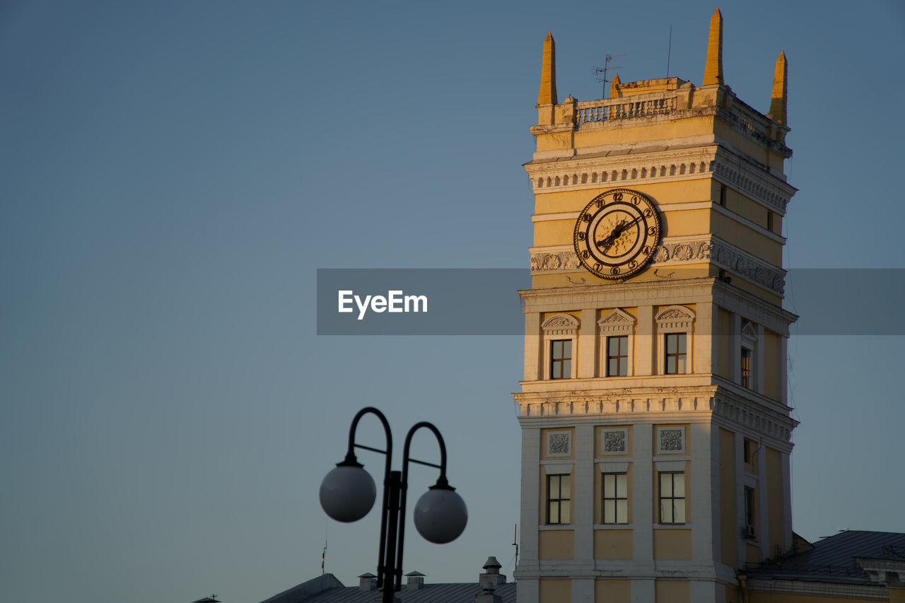 Low angle view of clock tower amidst buildings against sky