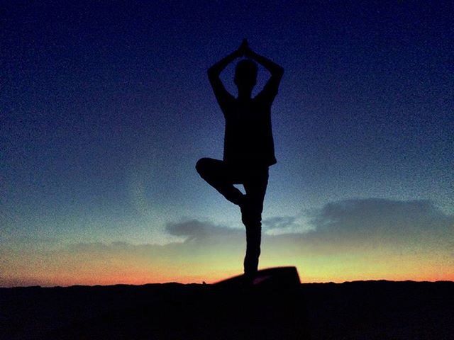 SILHOUETTE OF PERSON STANDING AGAINST SKY AT SUNSET