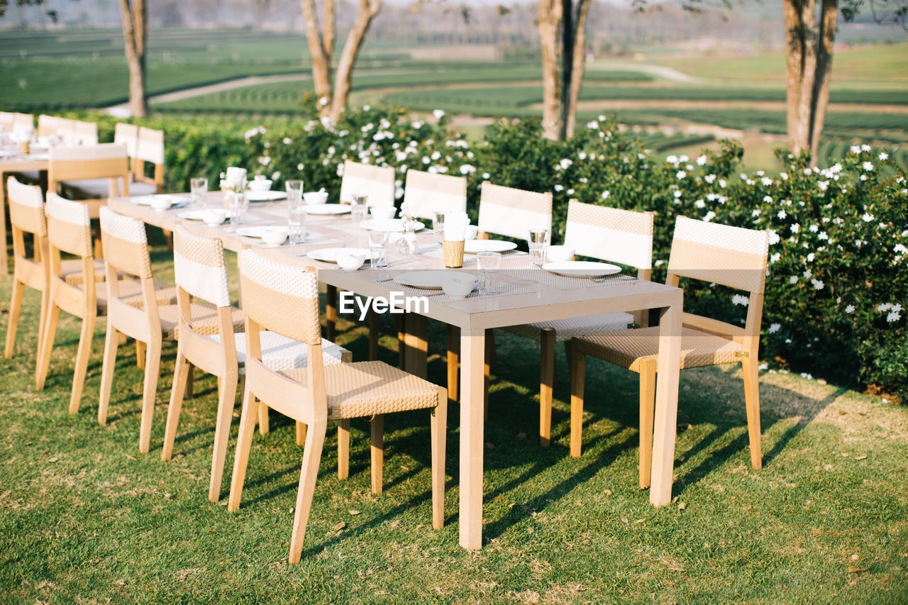 Empty chairs and tables arranged on field