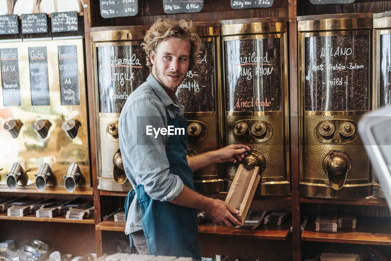 Coffee roaster in his shop filling bag with coffee