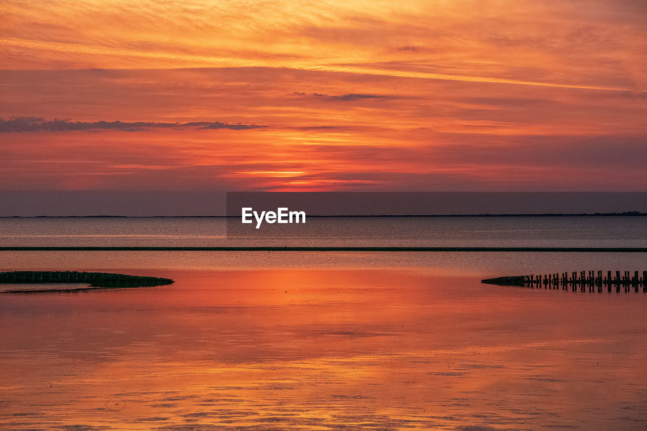 Scenic view of sea against romantic sky at sunset