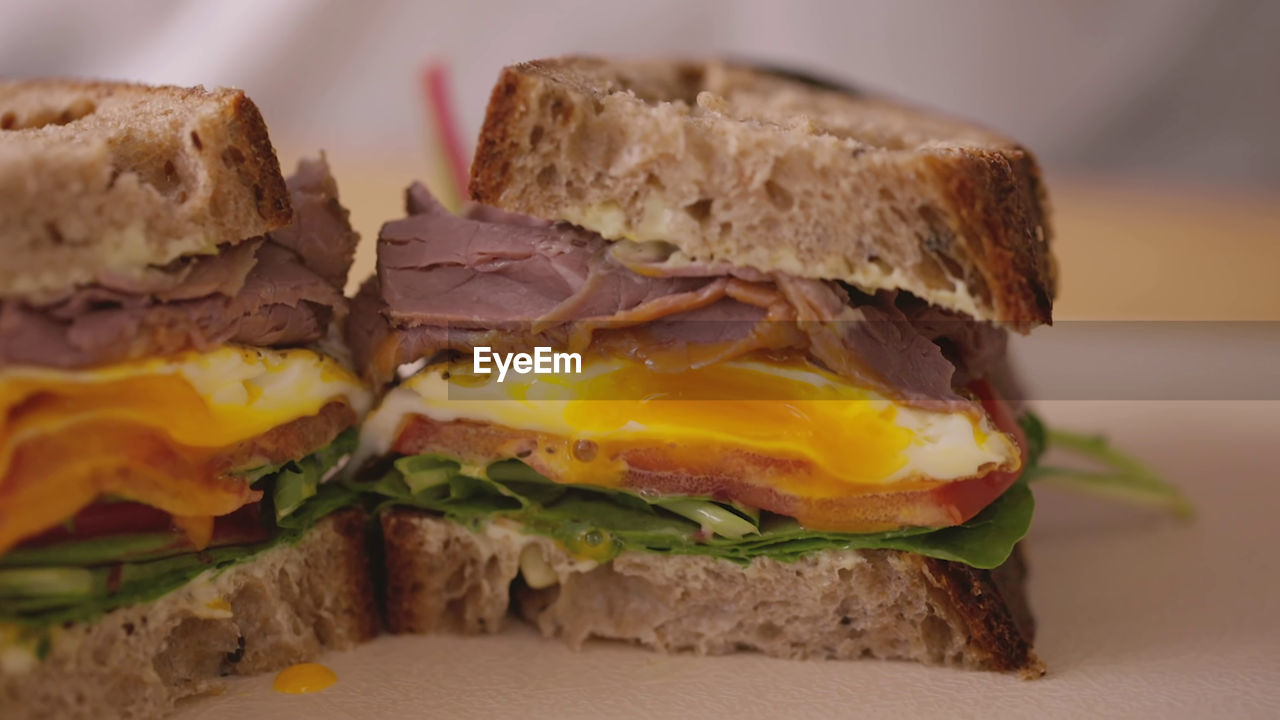 Sandwich with beef, over easy egg, and salad 